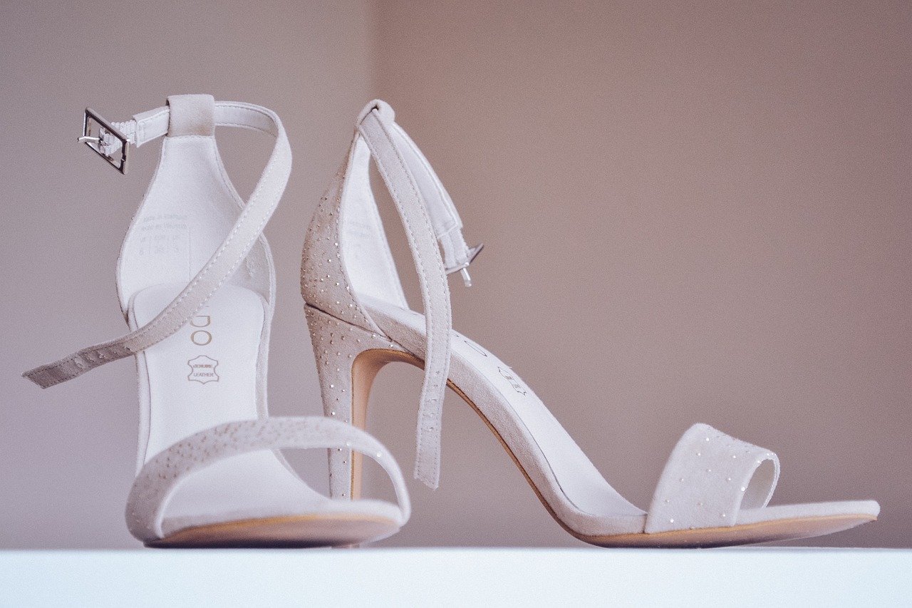 A sophisticated pair of white high-heeled shoes, perfect for formal and bridal occasions.