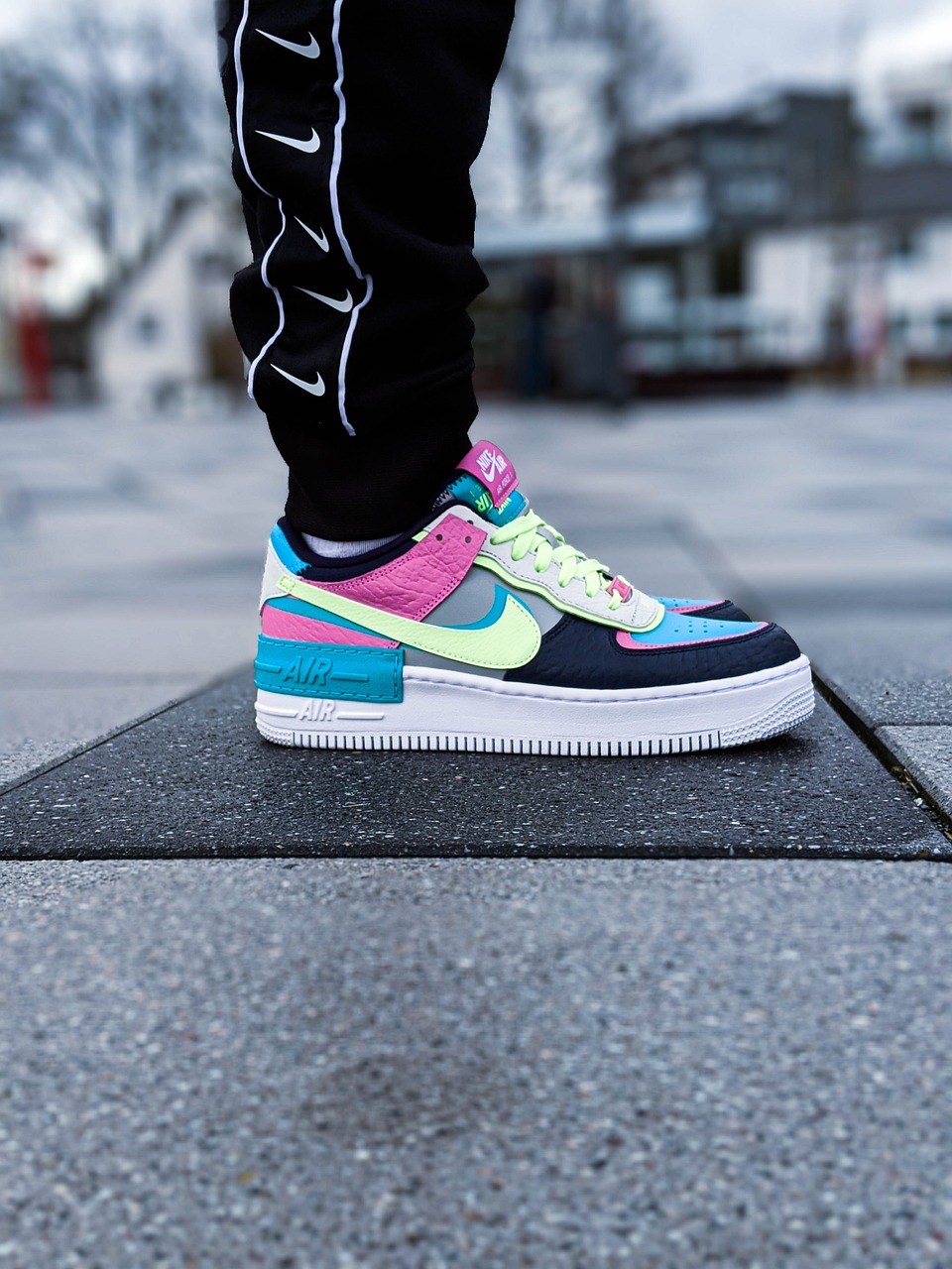 A close-up of a person’s foot wearing vibrant, colorful sneakers.